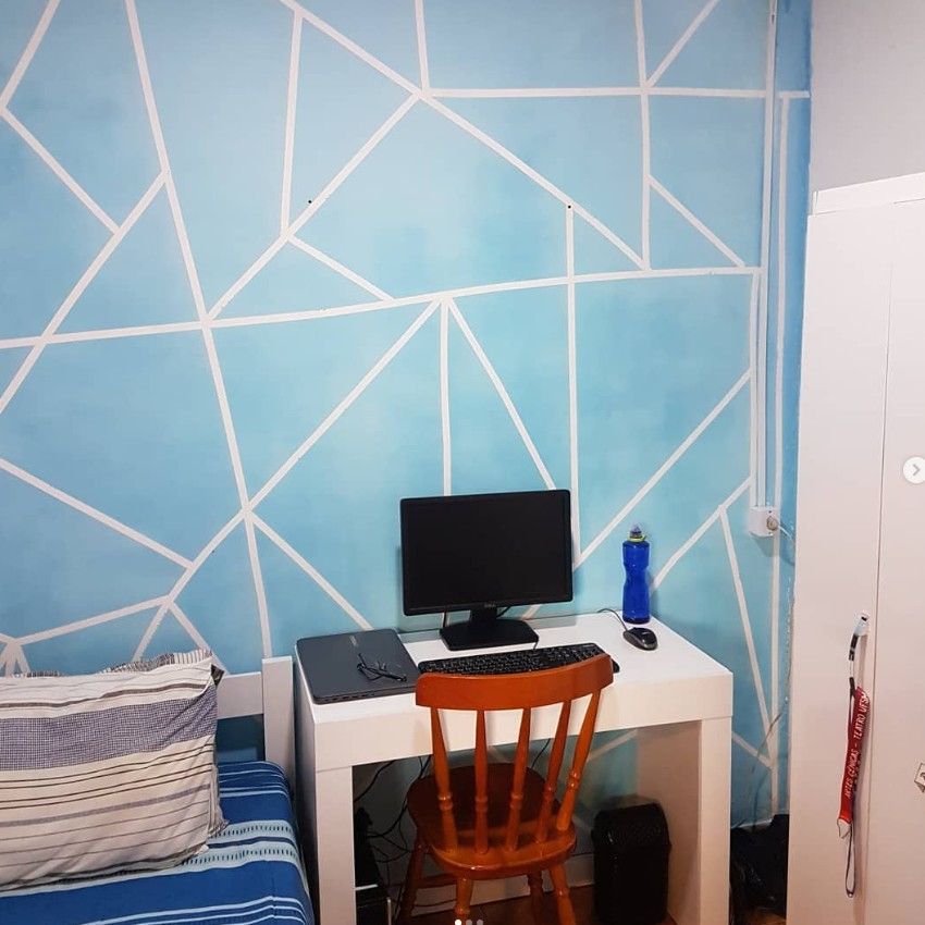 Quarto individual com escrivaninha e parede decorada